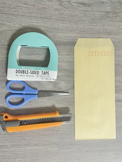 材料は茶封筒・両面テープ・はさみ・カッター（▶手順は次へ）