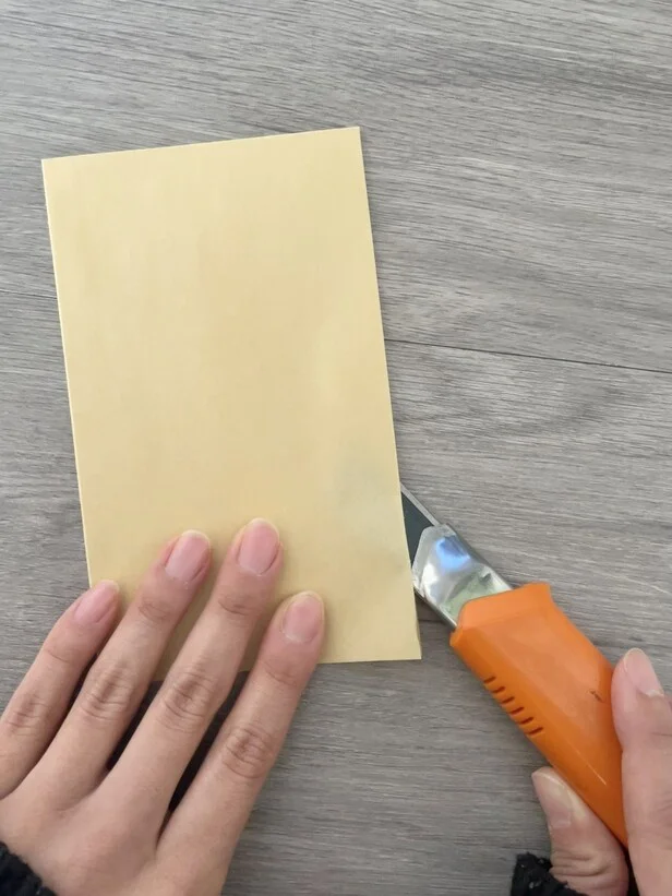 茶封筒の両サイドをカッターで切り開く（▶次へ）