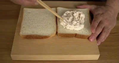食パン1枚にささみマヨを広げ、もう1枚でサンドし、上から押さえる
