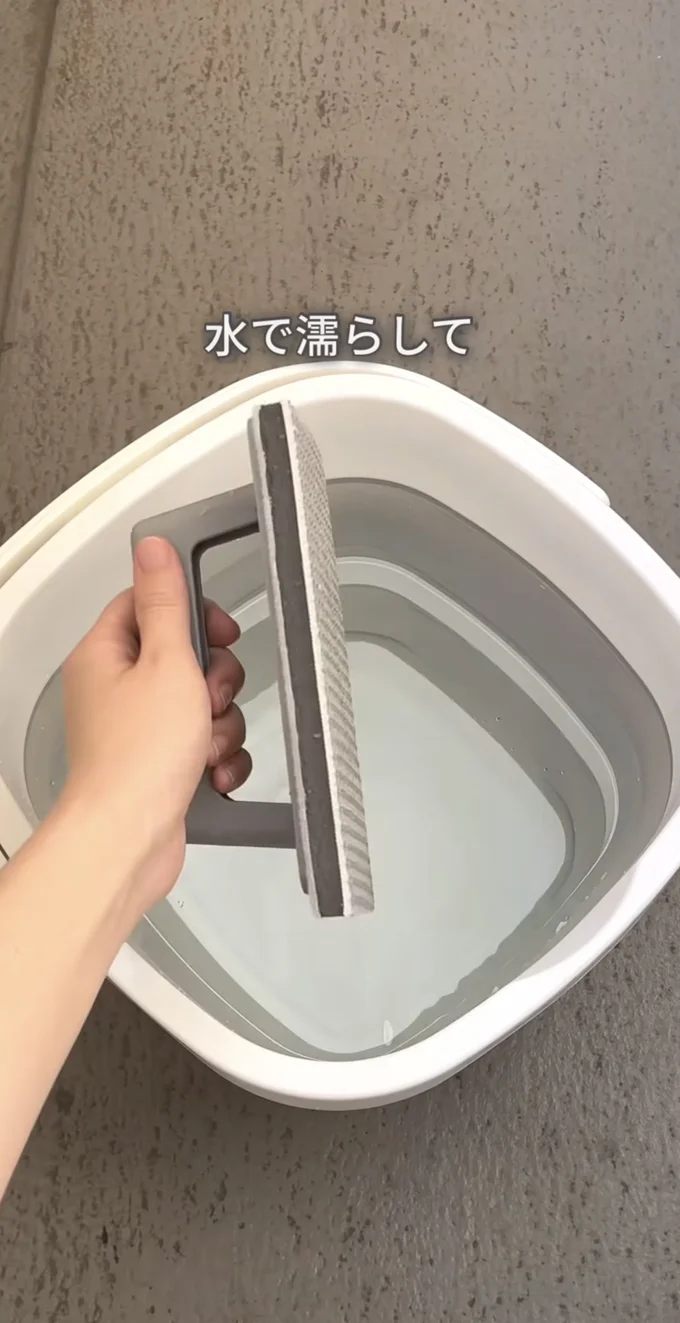 次に100円ショップの玄関・ベランダ用ブラシに水をつけます▶汚れがするーり（⇒次へ）