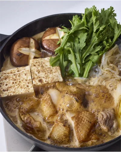 しらたき、とうふ、しいたけの順に加え、全体に火が通ったらしゅんぎくを加えてひと煮立ちさせる。