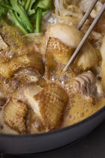 鍋を熱してねぎを入れ、表面がこんがりするまで焼く。鶏肉を皮目から焼き、焼き色がついたら返す。肉に火が通ってきたら調味料を順に加えて軽く煮る。アクが出たらとり除く。