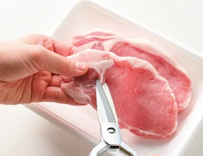 とんカツ用肉の筋切りをする