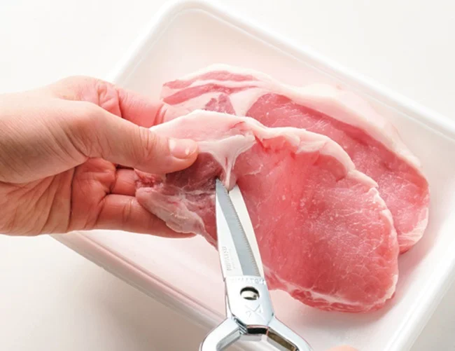 とんカツ用肉の筋切りをする