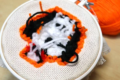 オレンジの毛糸で顔周りをかわいく