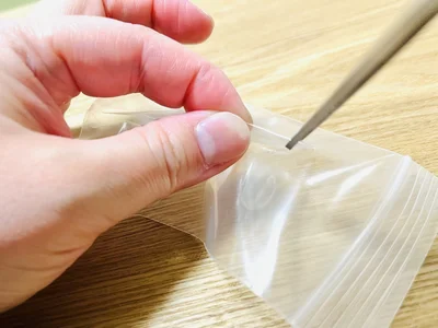 ハサミで収納パックに穴を空けたら…（▶次へ）