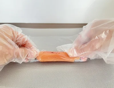 ラップをたらこに密着させるように、きつめに巻いて…（▶次へ）