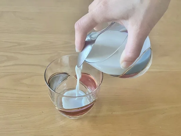 スプーンを注ぎ口にして傾ける（▶注いだ後のコップの様子は？）
