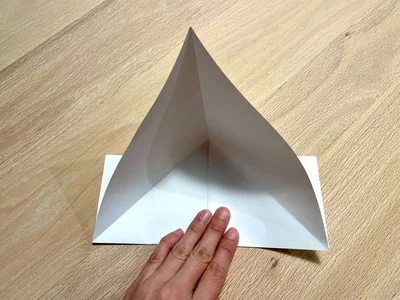 開いたら、真ん中を押さえて底にしっかりと折り目をつける（▶次へ）