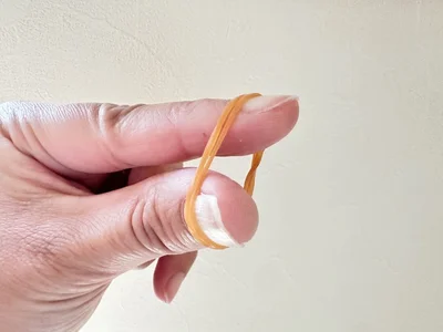S字フックをポールにかけたら、ゴムを二重にして指にはめます（▶次へ）