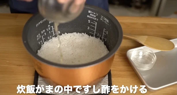 熱い炊飯窯の中ですし酢を混ぜる