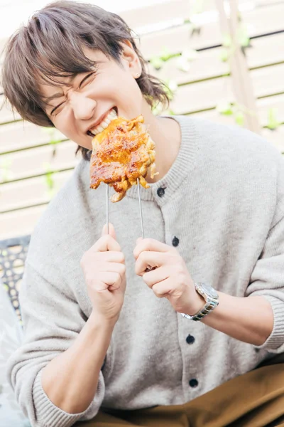 鶏肉にかぶりつく小山さん