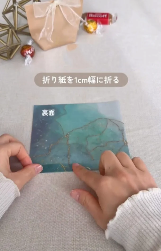 裏面下部分を1センチ折る▶1センチ折った部分を持ちながら…（⇒次へ）
