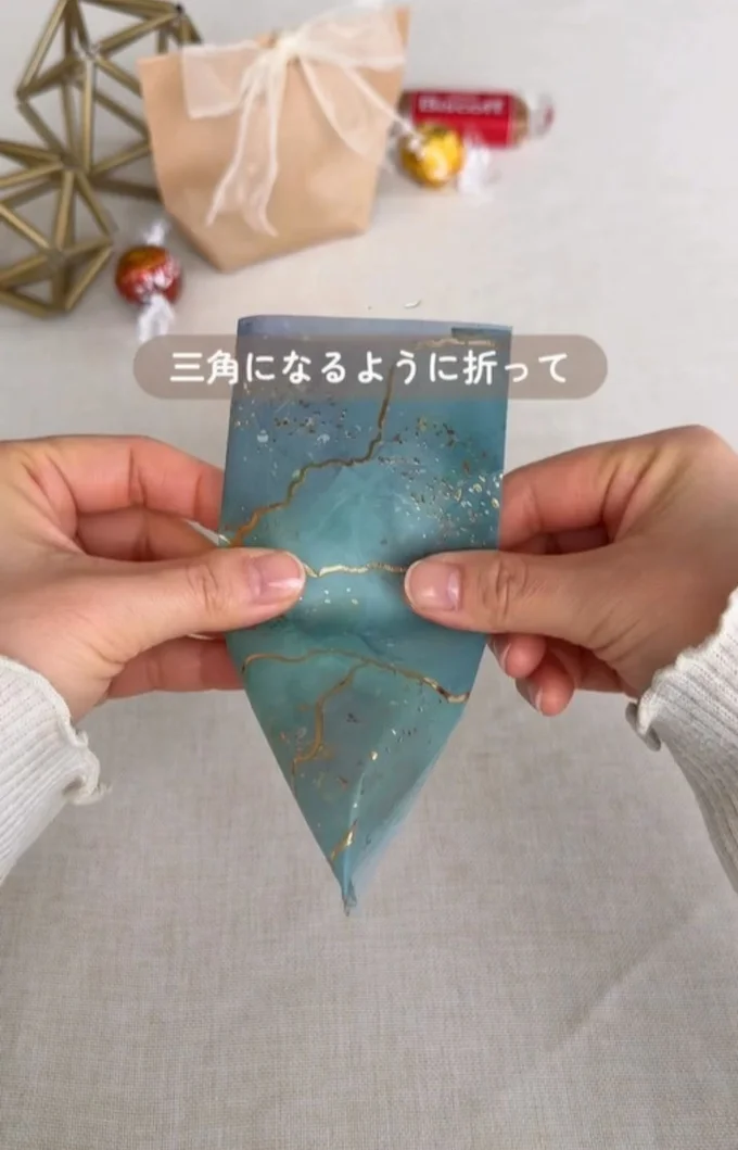 三角になるように折る▶仕上げにシールを貼って…（⇒次へ）
