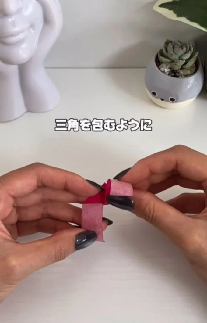 三角を包むように折る▶さらに…（⇒次へ）