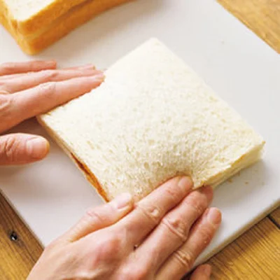 2枚のパンで具をはさみ、四辺を指先でしっかり押さえてパンどうしをくっつける