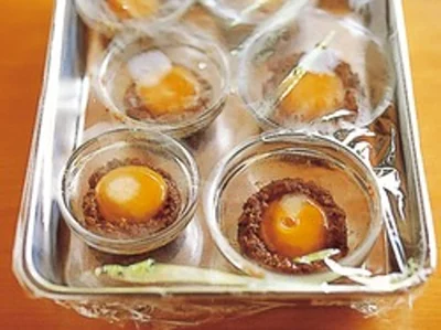 小さな器にみそを薄くぬったら卵黄をのせる。何個か同時に作る場合は、バットなどに並べてバットごとラップをかけて冷蔵庫に入れて。
