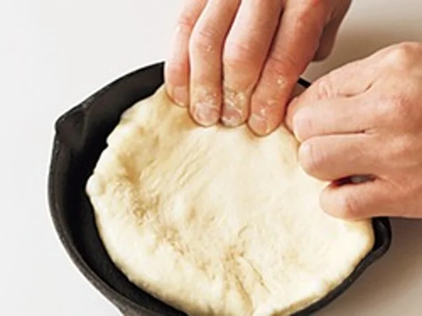 ピザ生地は指先でのばしながらスキレットの側面までしっかり敷き込んで。厚みが均一になるようにして。
