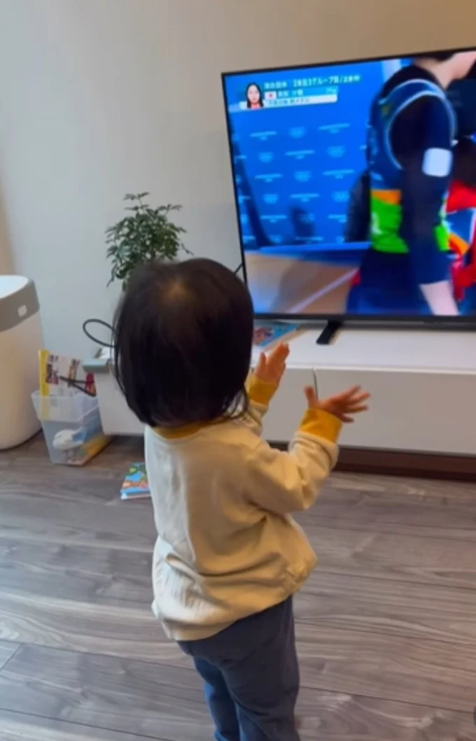 テレビを見て拍手をする女の子（⇒次へ）