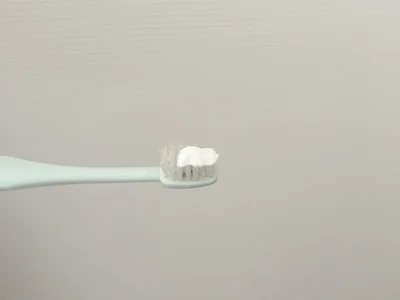 歯ブラシに歯磨き粉を適量出す（▶次へ）