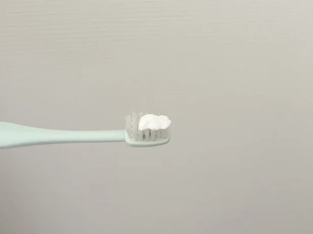 歯ブラシに歯磨き粉を適量出す(▶次へ)