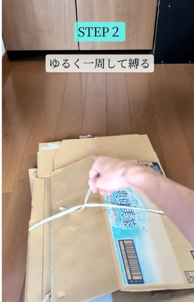 紐でゆるく一周して縛る▶段ボールの端を…（⇒次へ）