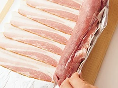 豚肉の端の細い部分は、内側に折り込んで太さを均一にすると巻きやすい。また、ベーコンを巻くときは、豚肉を中に押し込むようにして巻くとうまくいく。