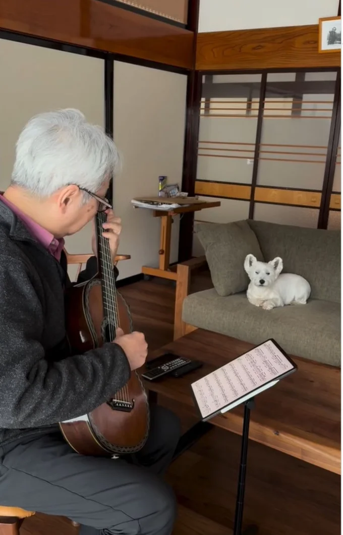 飼い主さんのギター演奏を聴き入る「シロップくん」(⇒次へ)
