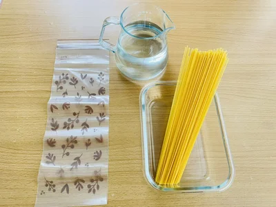 乾麺のパスタ、水、フリーザーバッグなどの容器（▶手順は？）