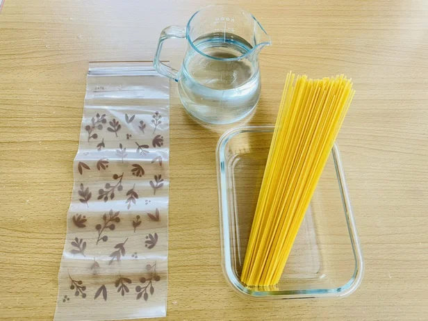 乾麺のパスタ、水、フリーザーバッグなどの容器(▶手順は?)