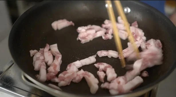 細切りにした豚バラ肉を炒める