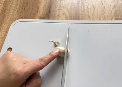 にんにくの両端を切り落とす（▶次へ）