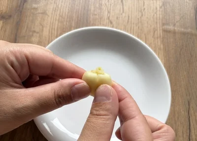 にんにくを押すと、芽の先端が断面からにゅっと出てくる（▶次へ）