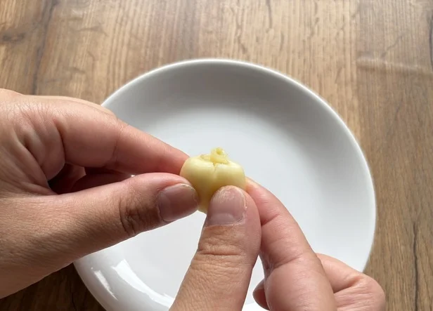 にんにくを押すと、芽の先端が断面からにゅっと出てくる(▶次へ)
