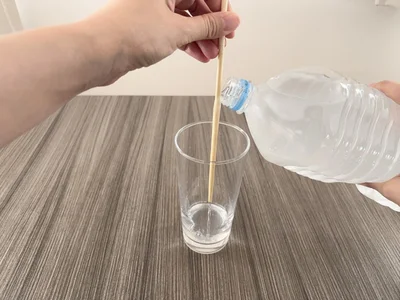 箸の上部を持って立て、ペットボトルの口を当てる（▶次へ）