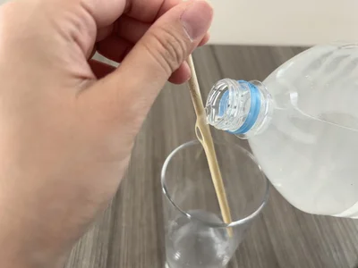 ペットボトルをゆっくり傾け、中身を箸に伝わせて注ぐ（▶結果へ）