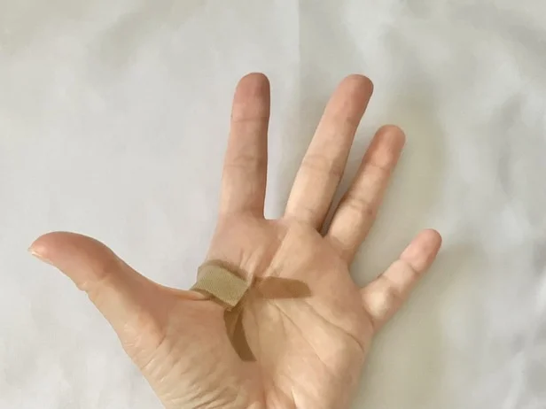 両端から切れ目を入れた粘着テープを大きく広げて貼ると…(▶次へ)