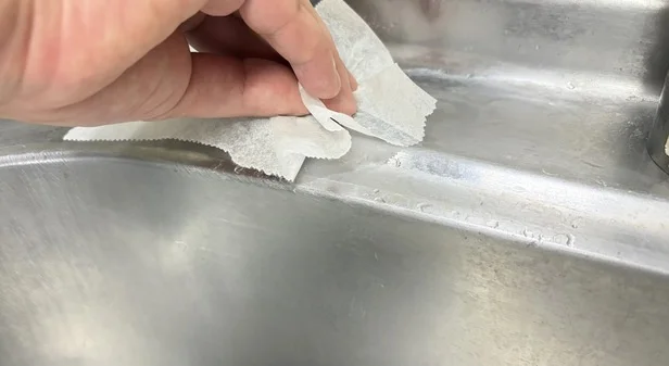 パックしたクッキングシートでこする（▶次へ）