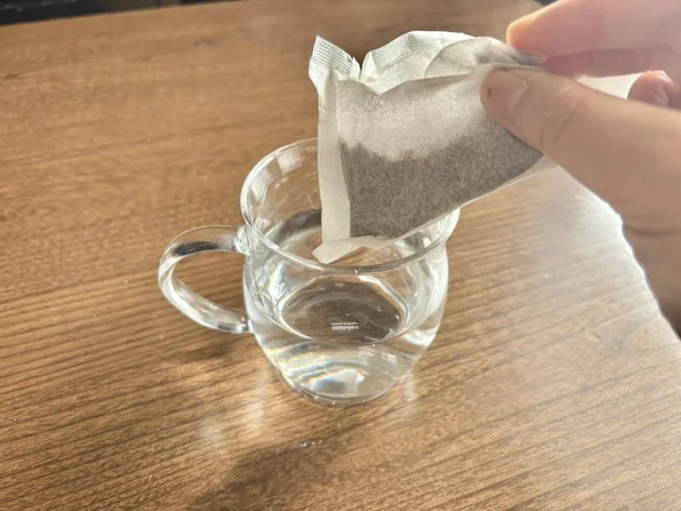 麦茶パックを水が入った耐熱マグカップに入れます(▶次へ)