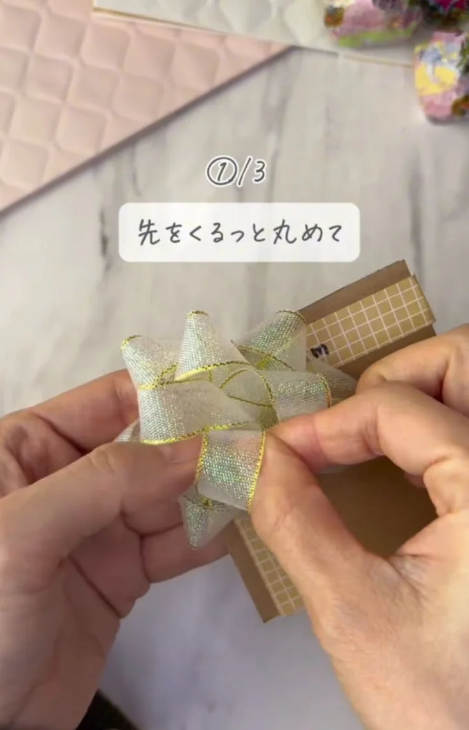先端をくるりと丸めて針に刺す▶親指で抑えながら…(⇒次へ)