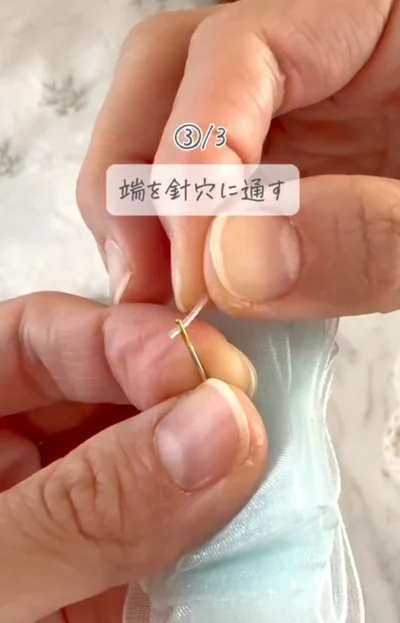 糸状にカットしたリボンの端を針穴に通す▶じゃばら折りしたリボンを…（⇒次へ）