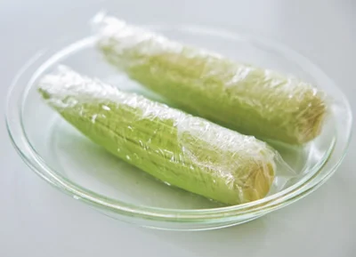 とうもろこしは内側の薄い皮を数枚残して、水けをつけたまま1本ずつラップで包む