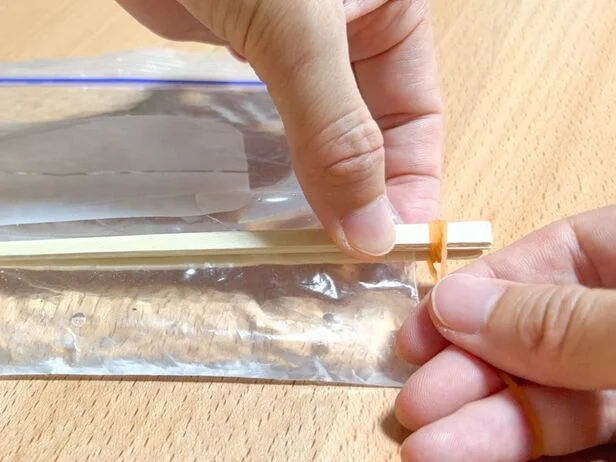 割りばしの両端を輪ゴムで固定する(▶次へ)