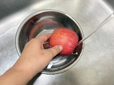 皮も食べるので、まずはりんごをよく洗う（▶次へ）