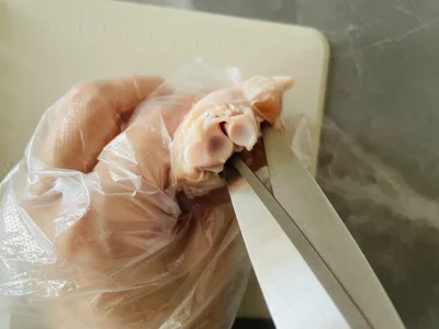 骨の周りの筋をキッチンバサミで断ち切る（▶次へ）