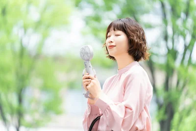 ハンディファンで涼む女性