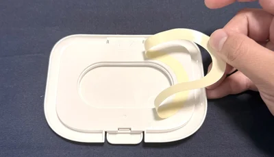 ウェットティッシュの蓋のはくり紙を剥がして…。（▶次へ）