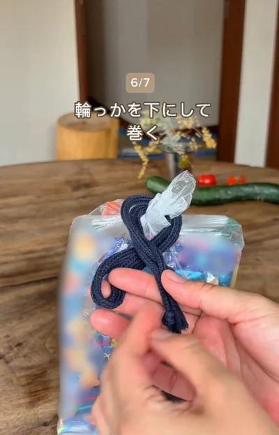 輪っかを下側にして巻く▶輪を袋の口にかけ…（⇒次へ）