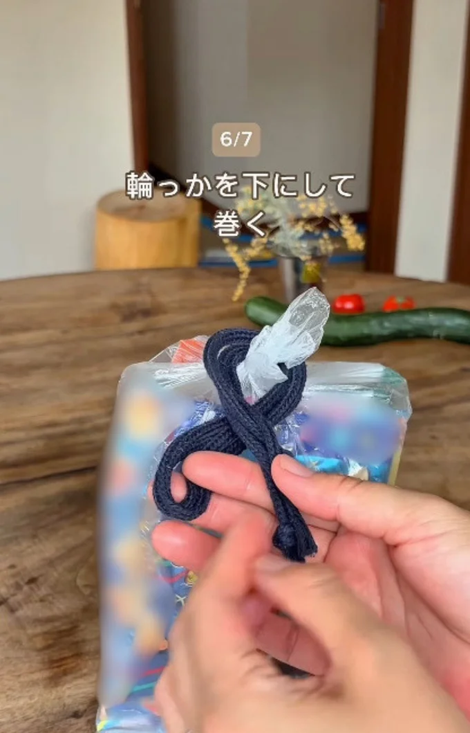 輪っかを下側にして巻く▶輪を袋の口にかけ…(⇒次へ)