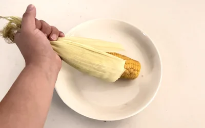 とうもろこしの先端を持って上下左右に軽く振ると…（▶次へ）